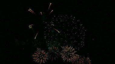 Kasvetli gece gökyüzünde parlayan 4k 'lık altın havai fişek videosu