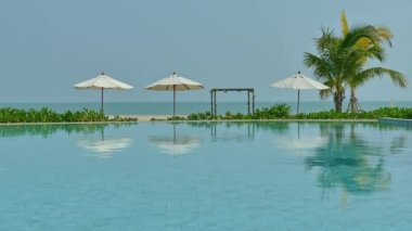 Güneş şemsiyeleri ve deniz ve havuz manzarası