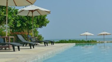 Güneş şemsiyeleri ve deniz ve havuz manzarası