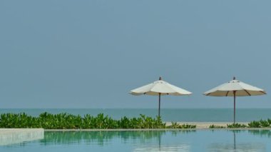 Güneş şemsiyeleri ve deniz ve havuz manzarası