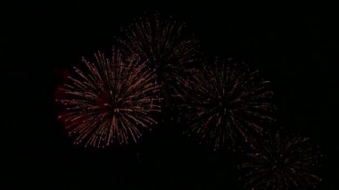 Karanlık gece gökyüzünde parlayan renkli havai fişeklerin 4K videosu