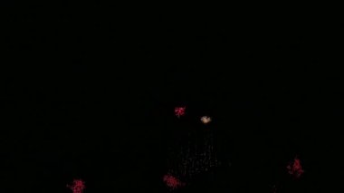 Karanlık gece gökyüzünde parlayan renkli havai fişeklerin 4K videosu