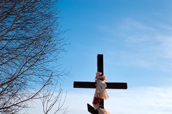 Haut de croix de culte avec des fleurs — Photo