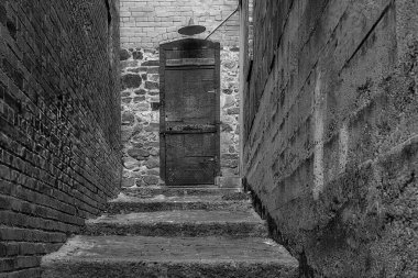A rustic iron door at the end of a brick hallway in Bisbee, Arizona