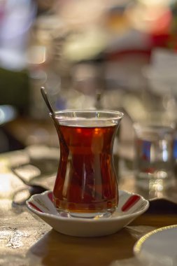 Açık havada kaşıkla sıcak Türk çayı. Türk çayı ve geleneksel Türk kültürü kavramı. Dikey. Kapat.