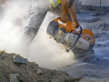 Bir işçi bir fayansı bir sürü dumanla elektrikli bir öğütücüyle boydan boya keser. Kirlilik kavramı