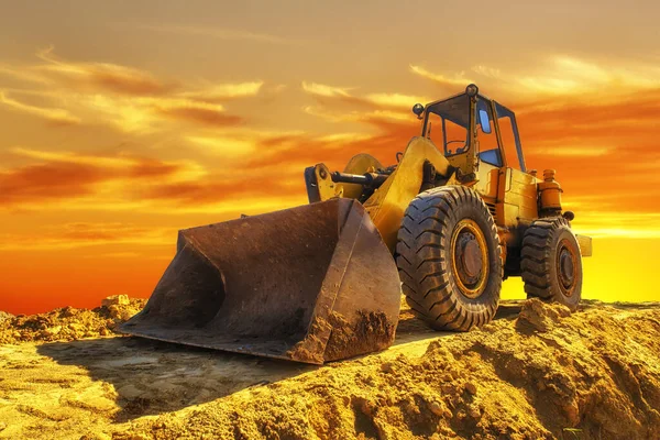 一辆停在美丽的日落前的黄色挖掘机 — 图库照片