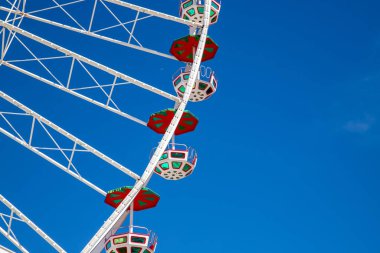 Geniş bir dönme dolabın bir bölümü açık mavi gökyüzüne ayarlanmış.