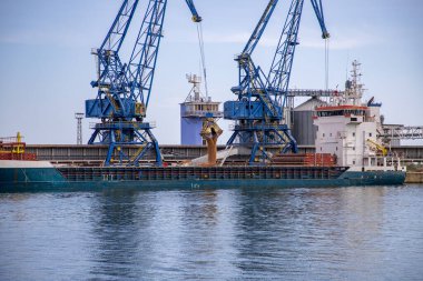 Endüstriyel Liman Görünümü Mavi Vinçler Büyük bir kargo gemisine kum ya da kum yüklüyor