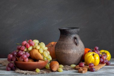 Kırsal bir hayat sürüyor. Sonbahar koleksiyonu. Tahta bir masada hasat ve eski bir sürahi. Pencereden gelen doğal ışık.