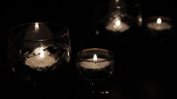 Свечи в стакане на темном фоне — стоковое видео