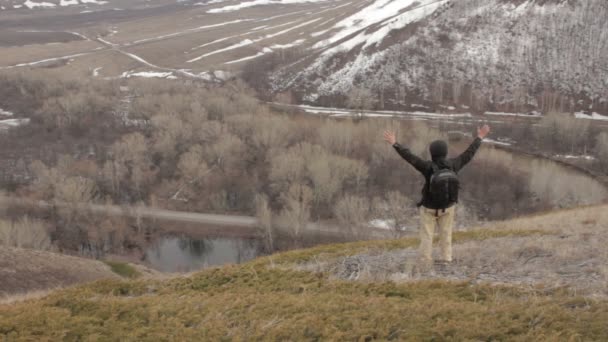 En man med ryggsäck på ett berg — Stockvideo