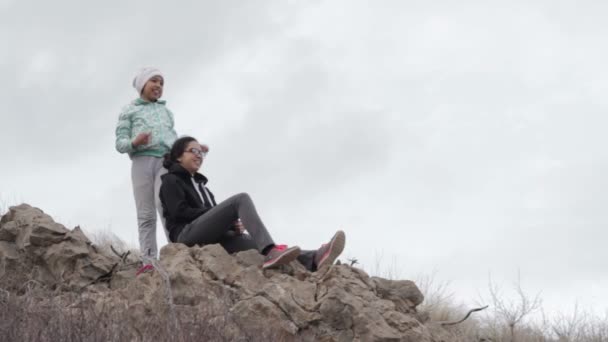 Chica joven descansando sobre rocas — Vídeo de stock