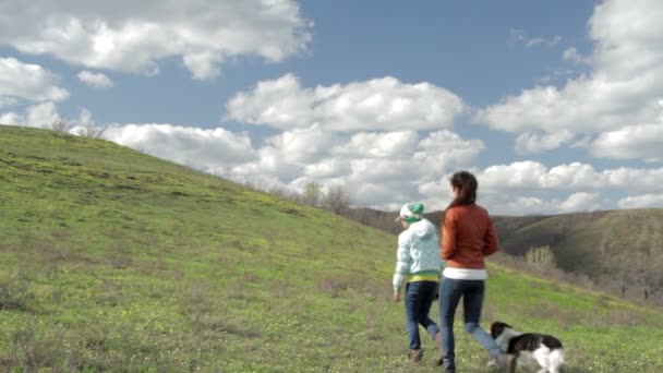 Meninas com um cão andando na natureza — Vídeo de Stock