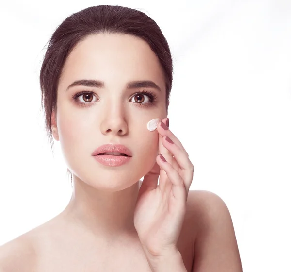 Bella modella applicando trattamento cosmetico crema sul suo viso sulla pelle bianca fresca, sorriso — Foto Stock