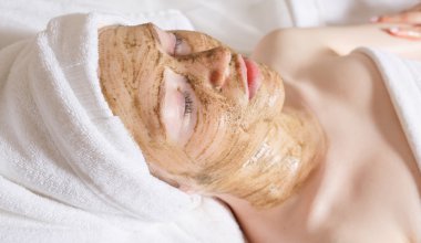 Yüz maskeli güzel bir kadın, spa tedavisi.