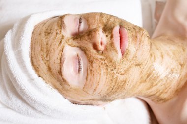 Yüz maskeli güzel bir kadın, spa tedavisi.