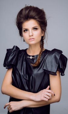 Portrait of young beautiful woman in leather black  dress with natural beauty, nude makeup, hairstyle