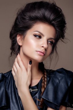 Portrait of young beautiful woman in leather black  dress with natural beauty, nude makeup, hairstyle