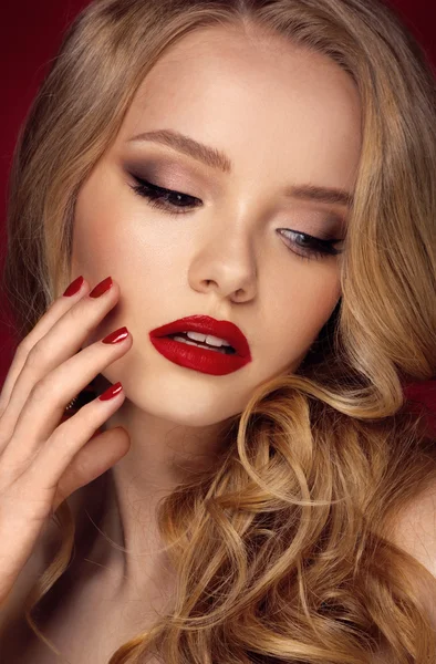 Schönes Gesicht eines Models mit blauen Augen.lockiges Haar. Rote Lippen. Studioporträt. — Stockfoto
