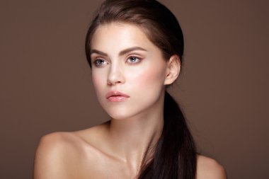 Güzel kadın modelinin göz kamaştırıcı portresi. Günlük makyajlı ve romantik dalgalı saç stili..