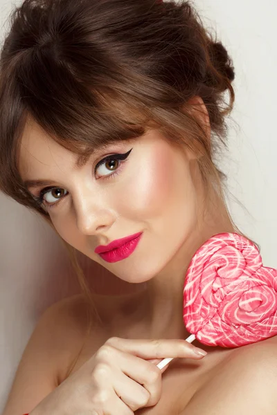 Módní make-up. Krásy dívka portrét drží barevné lízátko. Horké červené rty. — Stock fotografie