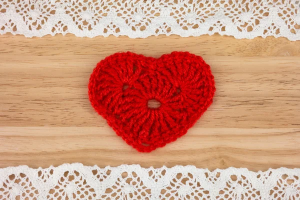 Gebreide hart op houten achtergrond met kant — Stockfoto