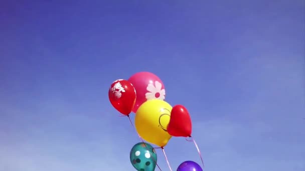 Κόμματος πολύχρωμο μπαλόνι επιπλέουν στα μέσα του αέρα ενάντια σε ένα φωτεινό μπλε ουρανό. — Αρχείο Βίντεο