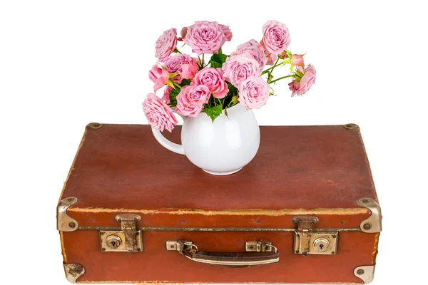 Цветы в кувшине на старом коричневом чемодане . — стоковое фото