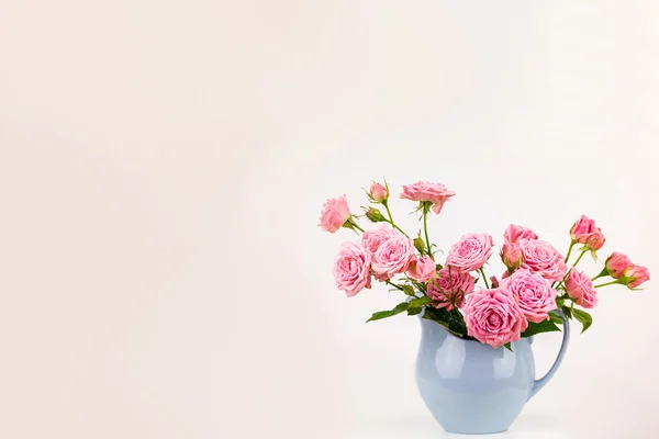 Flores cor de rosa em jarro azul . — Fotografia de Stock