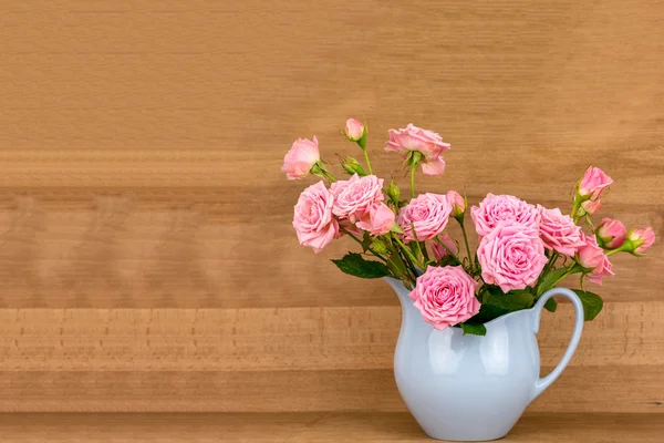 Flores cor de rosa em jarro azul . — Fotografia de Stock