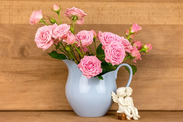 Roze bloemen in blauwe kruik. — Stockfoto