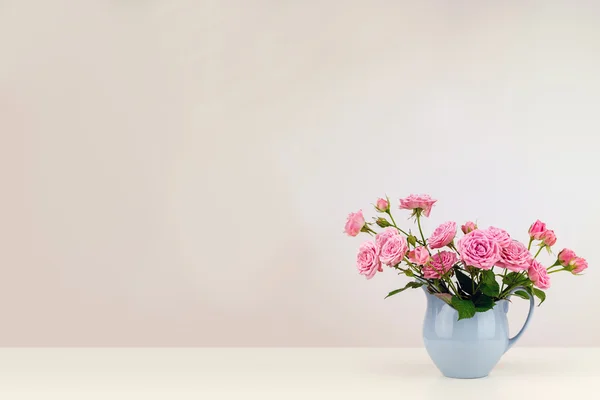 Flores cor de rosa em jarro azul . — Fotografia de Stock