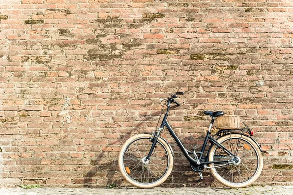 Bicicleta vintage retro preto com parede de tijolo velho . — Fotografia de Stock