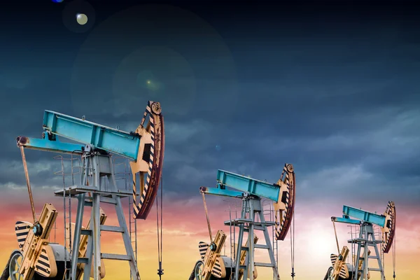 Olja pumpar vid solnedgången. — Stockfoto