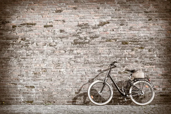 Bicicleta vintage retro preto com parede de tijolo velho . — Fotografia de Stock