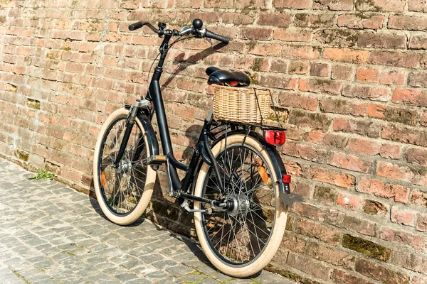 Bicicleta vintage retro preto com parede de tijolo velho . — Fotografia de Stock