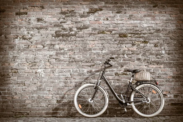 Bicicleta vintage retro preto com parede de tijolo velho . — Fotografia de Stock