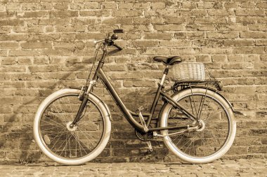 Siyah retro vintage bisiklet ile eski tuğla duvar.