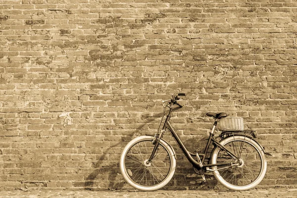 Bicicleta vintage retro preto com parede de tijolo velho . — Fotografia de Stock