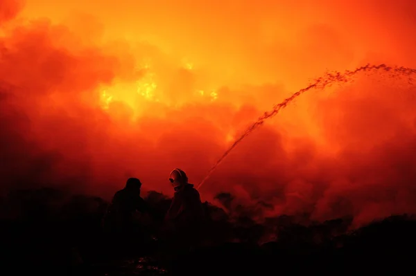 Silhouette du pompier combattant le feu de brousse la nuit . — Photo