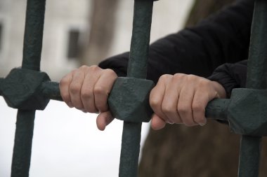 Demir parmaklıkları tutan el