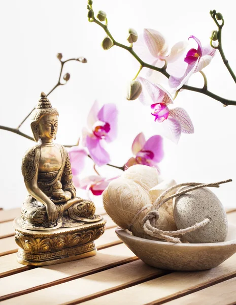 Мочалка и галька с Буддой и чувственными цветами — стоковое фото