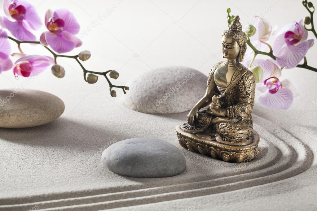 bronze Buddha in sand and flowers for inner beauty