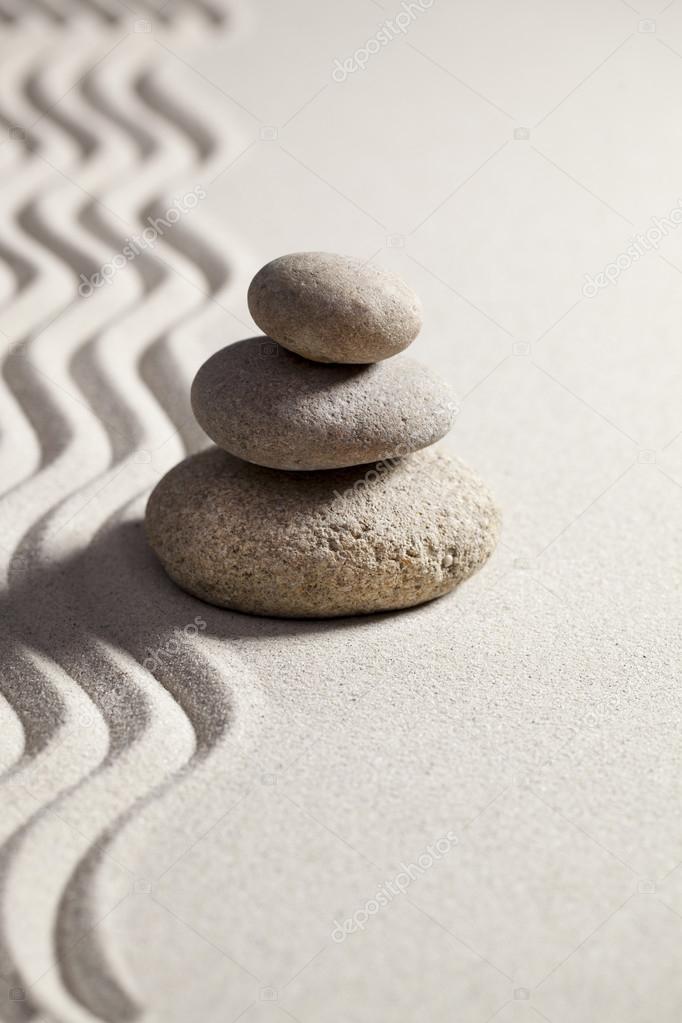 pebbles in balance with waves in sand for contemplation