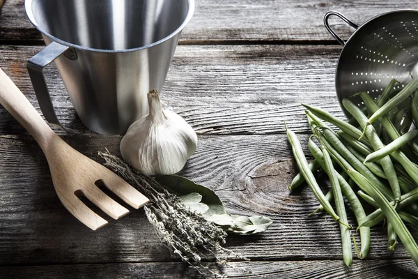 Bönor och örter med rostfritt stål köksredskap i trä för en hemmagjord recept — Stockfoto