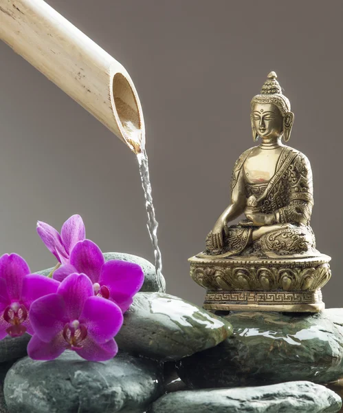 Boeddha met keien, orchideeën en bamboe voor de bron van vrede en meditatie — Stockfoto