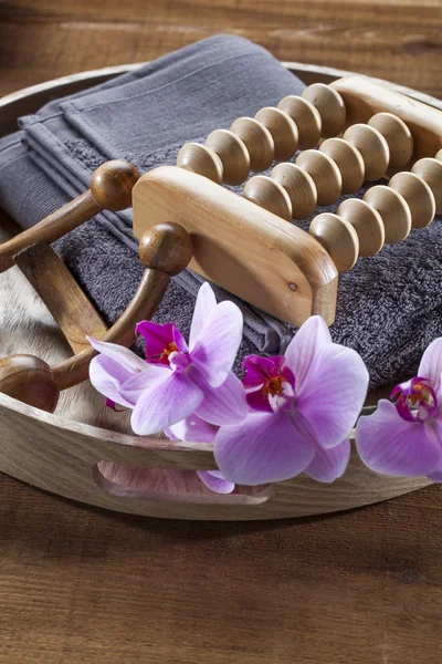 Bricka med handduk och orkidé blommor för avkoppling och massage — Stockfoto