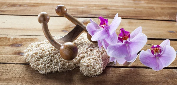 Massage tillbehör och orkidé blommor på trä bakgrund med orkidéer för avkoppling — Stockfoto
