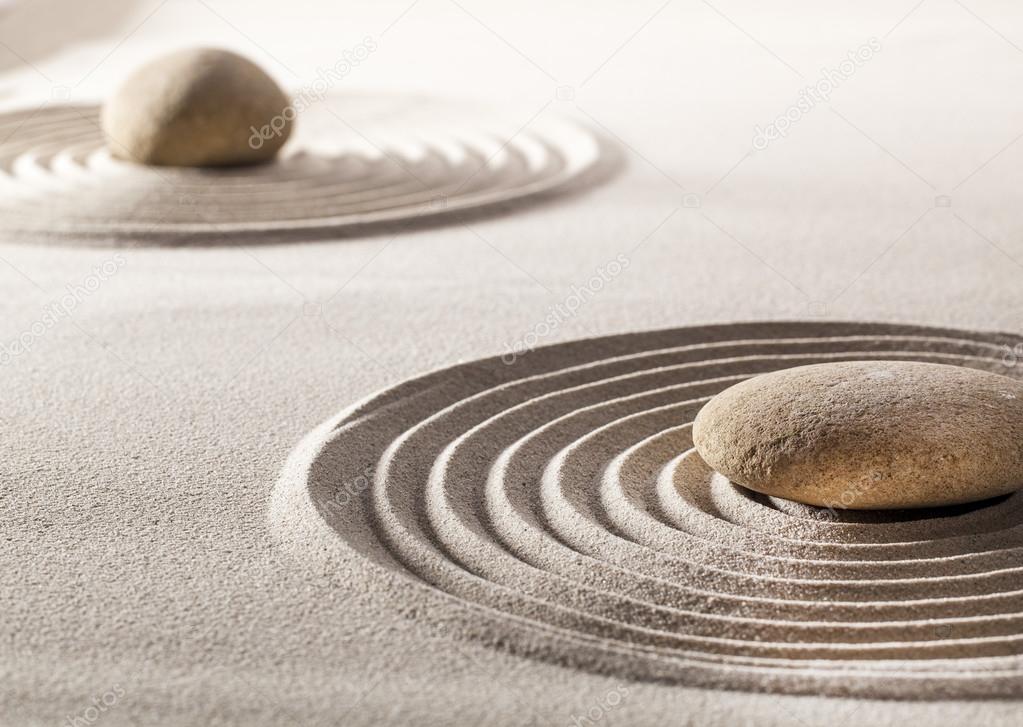 stones in the middle of pure waves in sand for concept of tranquillity